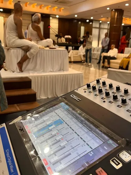 Here you can see my professional sound mixing setup in action during a spiritual discourse. I use top-tier equipment like this QSC digital mixer to guarantee crystal-clear audio for revered spiritual leaders and guest speakers.
