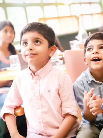 Two boys sharing a moment of wonder during a birthday party. We look for these quiet, candid interactions amidst the excitement.
