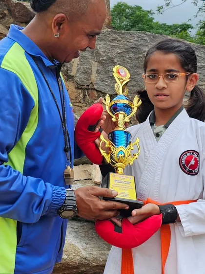 Presenting a trophy to a promising young karateka. Her potential is limitless with continued practice and discipline.