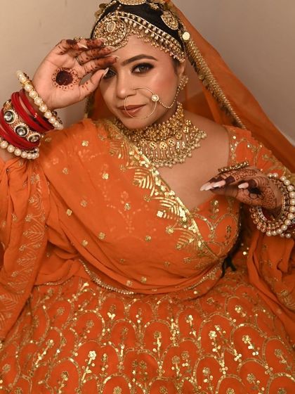 A playful pose showcasing the full orange outfit and the matching red choora.