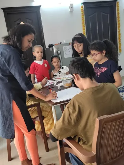 I always make sure to give each child individual attention. Here, I'm guiding a student through the initial drawing phase of our painting project, helping them build a strong foundation for their artwork.