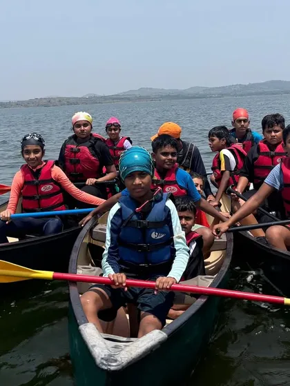 A group of young adventurers gets ready to set off in canoes at Vani Vilas Sagar, learning how to work together to paddle the larger boats.
