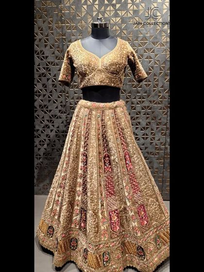 This bridal lehenga features a stunning combination of maroon and gold embroidery on a mannequin, highlighting the rich texture and design before it's even worn.