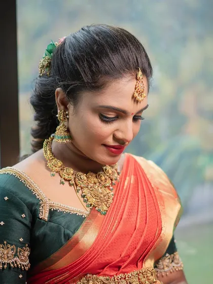 A close up of the traditional baby shower makeup for Archana. You can see the detail in the eye makeup and how the gold jewelry is perfectly balanced with the warm tones on her skin.
