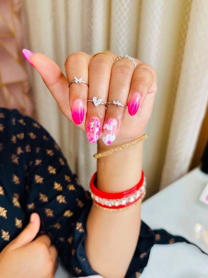 A side view of the pink ombre nails, showing the smooth transition of color and the placement of the art.