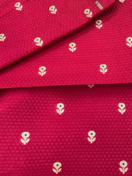 The texture on this pink Banarasi brocade is simply exquisite. The woven butti pattern gives it a classic feel, perfect for a traditional suit set or a contemporary gown.