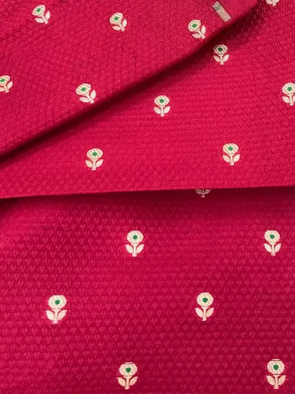 The texture on this pink Banarasi brocade is simply exquisite. The woven butti pattern gives it a classic feel, perfect for a traditional suit set or a contemporary gown.