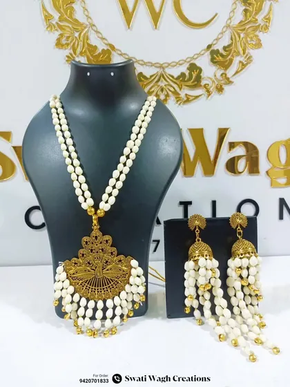 The intricate details of the golden pendant paired with a double-strand mogra necklace. This is a perfect fusion of traditional and floral artistry.
