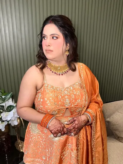 A side profile, showing her soft curls and the elegant design of her necklace.