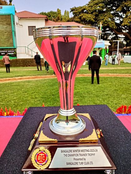 The Champion Trainer Trophy, a tall, slender silver cup.