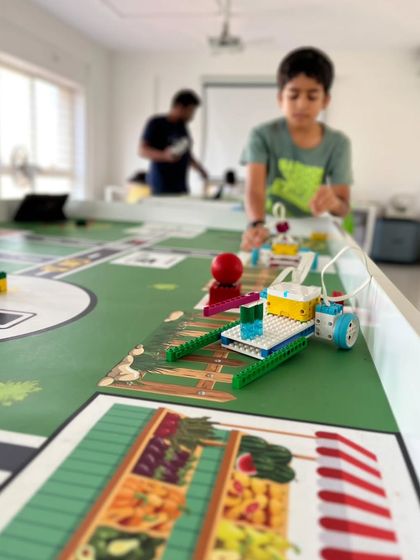 Our themed mats make learning more immersive. A student tests his robot on a challenge mat during summer camp, programming it to complete specific tasks and navigate the course.