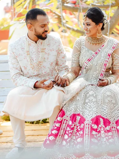 A quiet moment on a bench during Jeenal and Chirantan's wedding day. The soft light and their gentle interaction create a classic, romantic portrait.