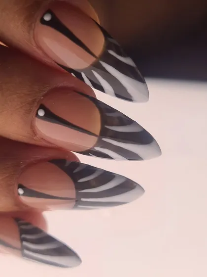 A close-up view of the sharp, graphic lines in this modern zebra print nail art.