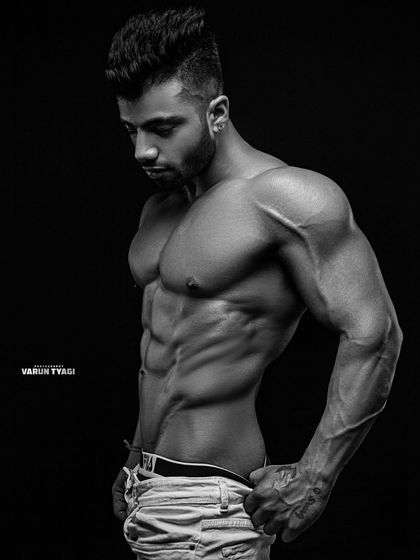 A black and white professional photo. This artistic shot highlights the lines and shadows of a well-conditioned physique.