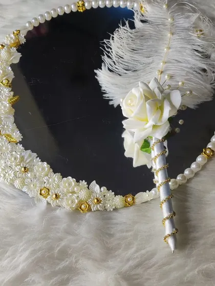 For the bride who loves modern elegance, I created this white and gold set. The mirror is decorated with delicate white flowers and pearls, paired with a matching feather pen. It’s a clean, sophisticated look for your special day.