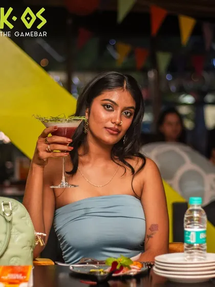 A guest posing with her cocktail, enjoying the new dishes and wild energy of our menu launch.