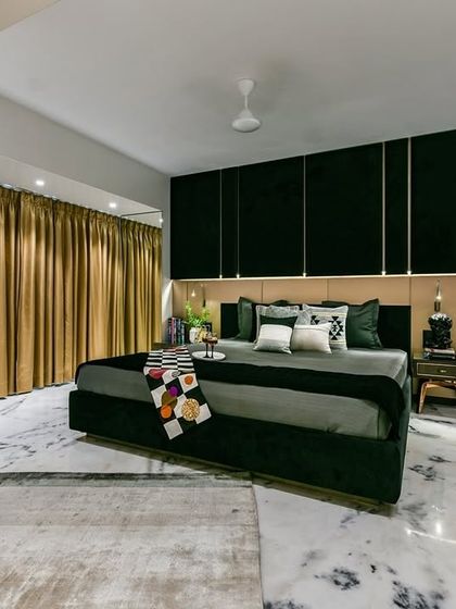 In the heart of this Mumbai home, the master bedroom unfolds like a tapestry of luxury. Indian marble flooring gleams, a metallic backboard reflects dreams, and a custom-made bed beckons with promises of blissful repose.