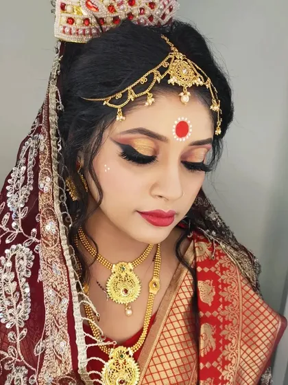 This Bengali bride's look features halo eye makeup with a golden shimmer, adding a touch of glamour to the traditional style.