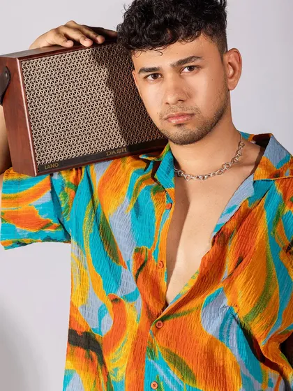 A closer shot of the tropical shirt, highlighting the bold colors and the chain necklace accessory. It’s a great example of how to style prints for men.
