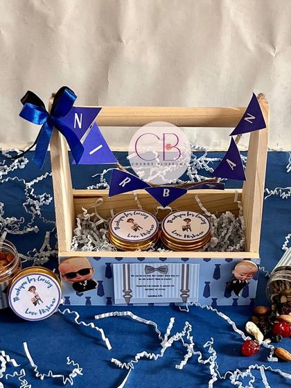 Our best-selling "Boss Baby" return favours are a huge hit. This pinewood basket option includes jars of almonds and mixed dry fruits, with personalised labels and a cute name banner.