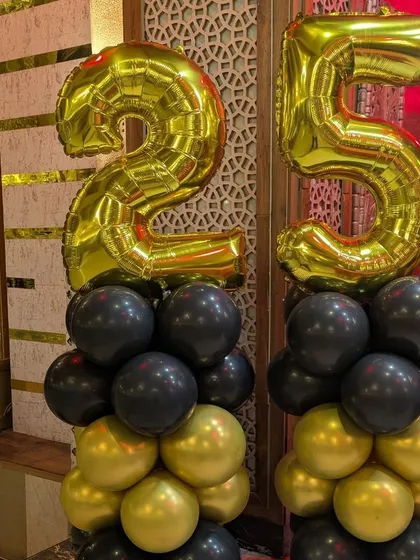 A close-up of the balloon pillars topped with large '25' foil numbers, a popular choice for milestone anniversary decorations.