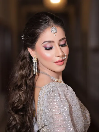 A side profile showcasing the beautiful hairstyle and the soft, shimmery eye makeup that completes this stunning engagement look.
