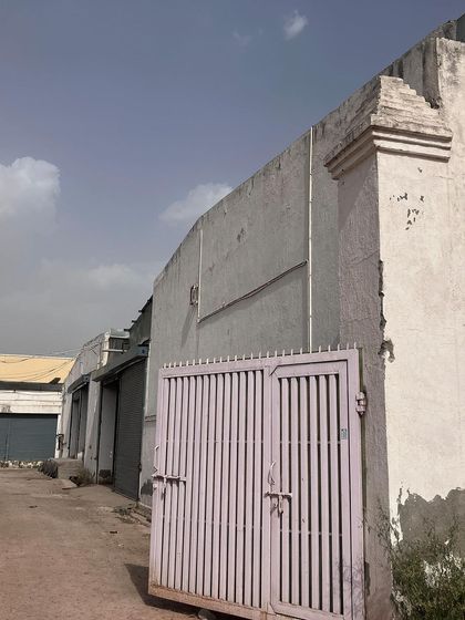 The exterior of a warehouse facility before installation. Identifying entry gates and perimeter walls is the first step in our security survey.