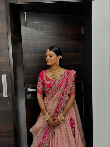 Her look is timeless, with a neat bun, traditional jewelry, and glowing makeup.