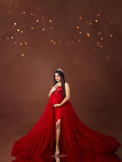 A moment of pure romance and magic. This portrait in a flowing red gown with a tiara and sparkling lights feels like a scene from a fairytale.