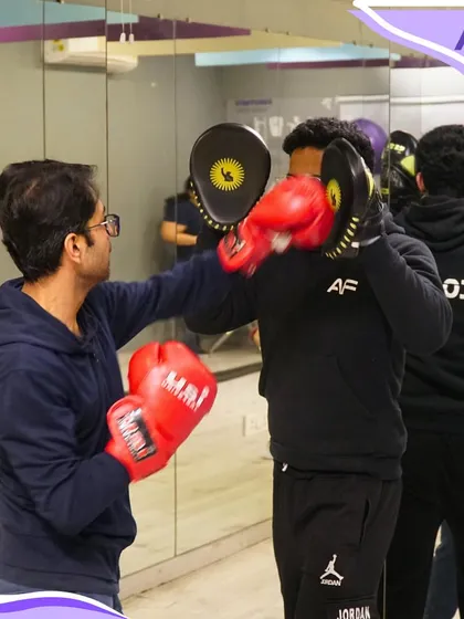 Our kickboxing classes include practical pad work to improve technique and power. Here, a member practices his punches with a trainer holding the focus mitts.
