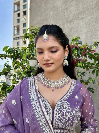 Another angle of this lovely purple lehenga look, focusing on the flawless makeup and the soft, natural light.