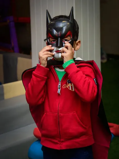 A little boy in a Batman mask, getting into character for a day of superhero fun.