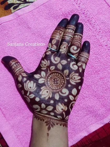 The cutwork design after the henna paste has been applied, showing the dark, rich colour of the fresh paste.