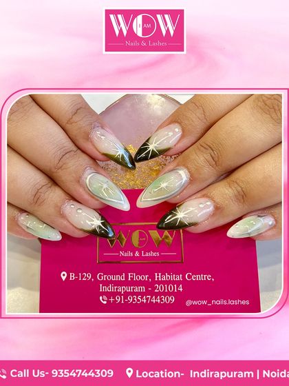 A celestial design on long, stiletto extensions. This look combines a sheer base with black and green accents, featuring stars and moons for a magical, otherworldly vibe.