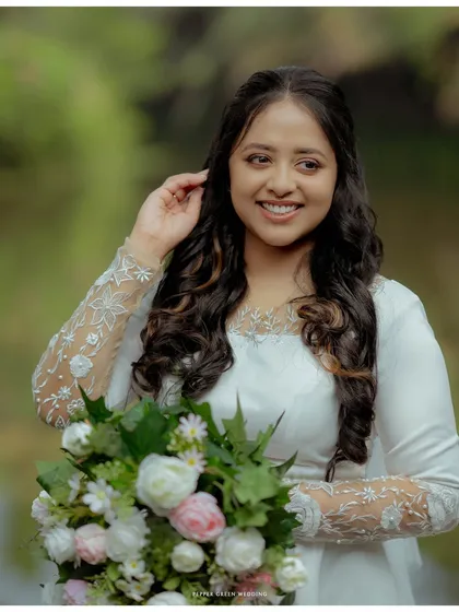 A lovely portrait of the bride, her smile radiant as she holds her beautiful bouquet. The natural setting enhances her natural beauty.