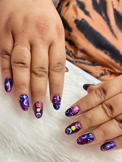Another look at the magical, galaxy-inspired nails, showing the full set and the beautiful mix of colors and celestial designs.