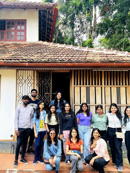 A group photo in front of a traditional Kerala-style homestay, our comfortable base for exploring Wayanad.