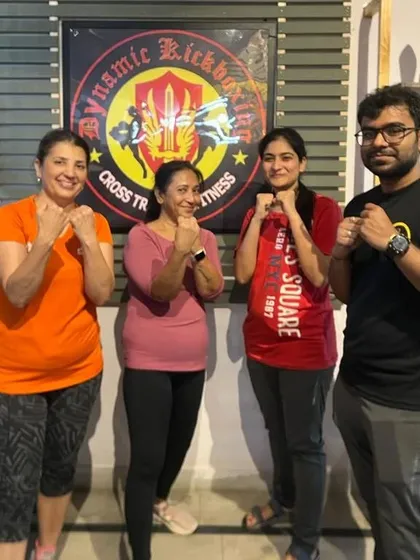 Happy souls with a positive attitude. Our members posing in front of the gym logo, proud to be part of the squad.
