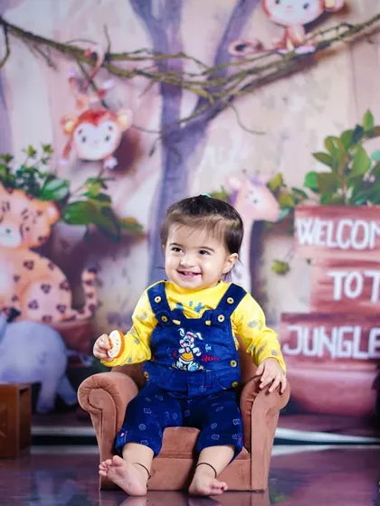 A big smile from our jungle explorer, sitting happily in a tiny armchair in our Vashi studio's jungle-themed set.