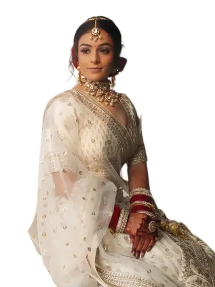 A clean, minimalist shot of the bride in her white lehenga. The makeup is elegant and understated, perfect for a modern wedding.