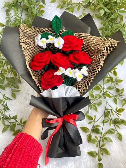 Holding up the beautiful red rose and white flower bouquet. It shows the size and feel of the arrangement, ready to be gifted.