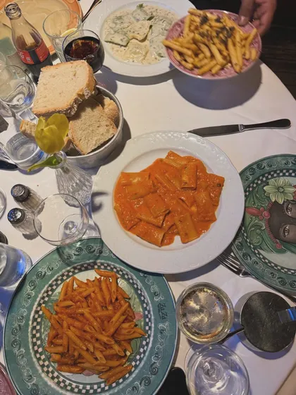 A table filled with our Italian specialties at a catered event. You can see the popular Rigatoni Alla Vodka, truffle fries, and other pasta dishes, showing a feast ready to be enjoyed.