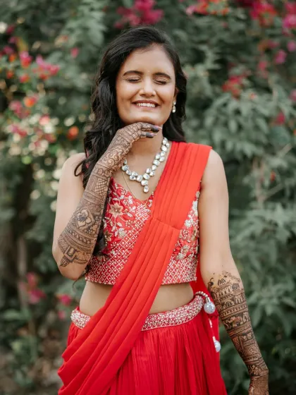 A moment of pure joy. This bride's happy expression says it all, as she shows off her full-arm bridal mehendi.