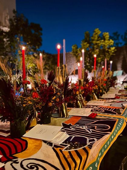 Another view of the long table at the Shivan & Narresh dinner, with vibrant florals and dramatic candlelight creating an immersive and high-fashion dining atmosphere.
