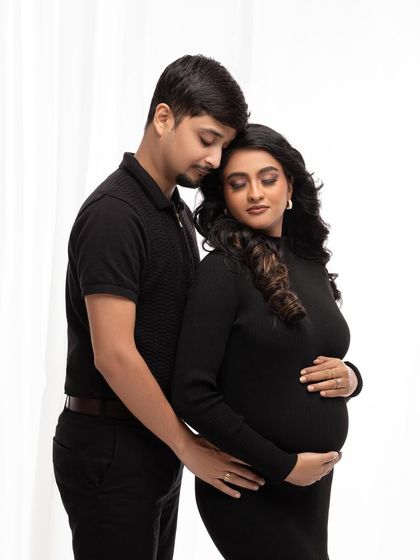 An intimate embrace, with both partners focused on the baby bump. This image is full of warmth and shared anticipation.