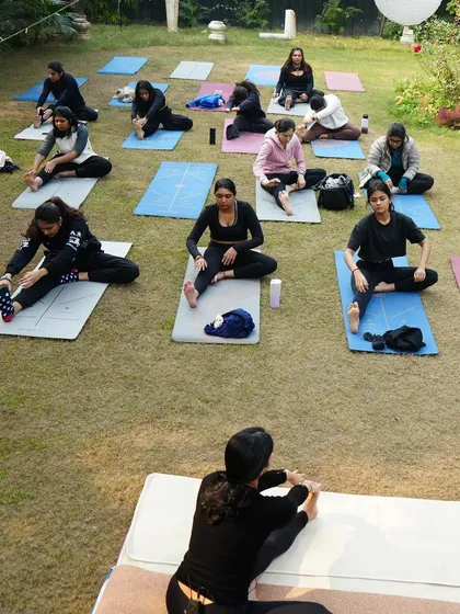 A different angle from our outdoor year-end class, showing students in various stages of their warm-up stretches. Everyone moves at their own pace.