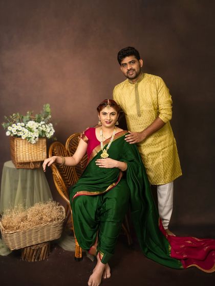 A beautiful family portrait. The partner stands supportively behind his seated wife, creating a classic and loving image of the couple.