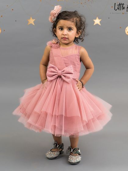 An adorable onion pink short dress with a big bow, perfect for a first birthday or toddler party.