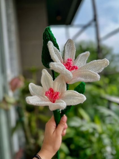 A close-up of two of our new crochet lily stems. You can see the intricate detail in each petal, all stitched by hand.