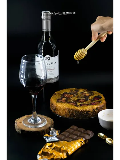 A perfect pairing of red wine, dark chocolate, and plum cake. This shot uses a dark background to create a rich, indulgent atmosphere, ideal for dessert menus or promotional content.